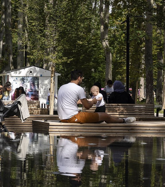 Un père et son fils près d'un plan d'eau, dans un parc de centre-ville