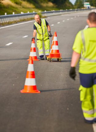 Collaborateurs de VINCI Autoroutes récupérant des plots sur la chaussée