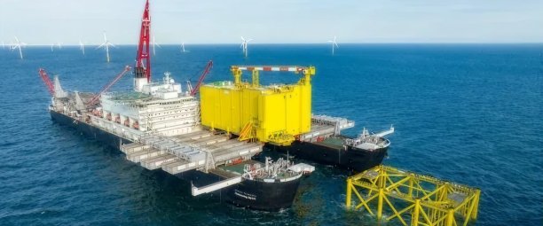 Installation en mer par le Pioneering Spirit, le plus grand navire de ce type au monde. La jacket est fixée au fond marin