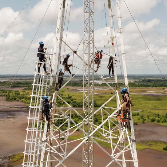 Ouvriers en intervention en hauteur sur un pylône, en Guinée