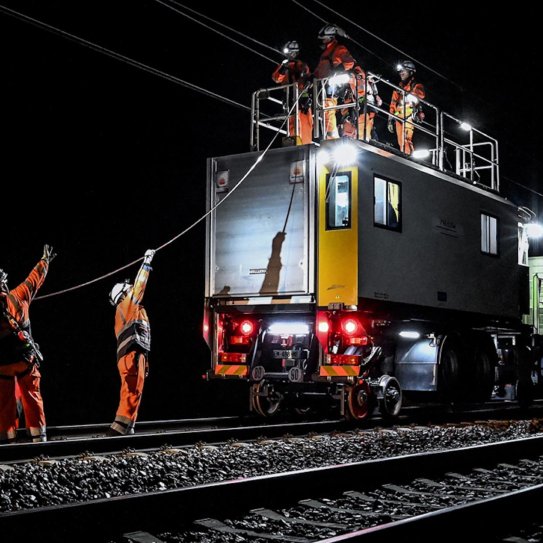 Ouvriers travaillant sur un chantier ferroviaire de nuit